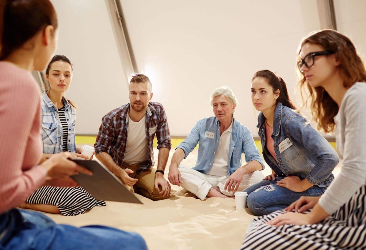 Young player commenting plan of colleague during discussion of principles of success at session